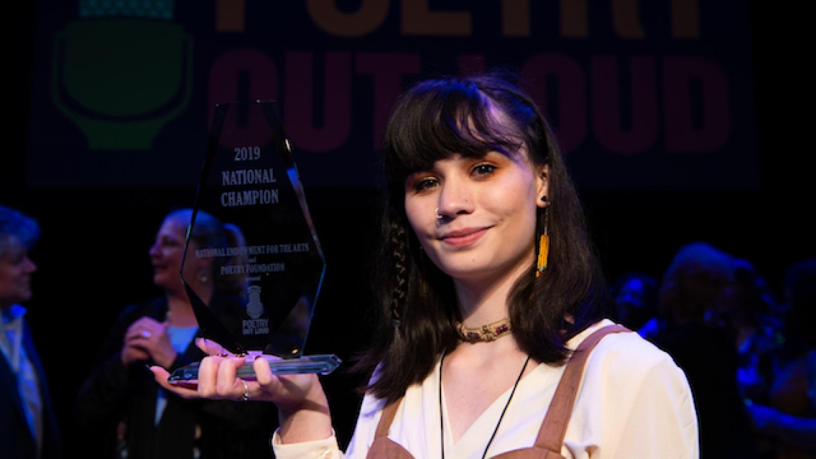 Isabella Callery holds her Poetry Out Loud National Champion glass trophy