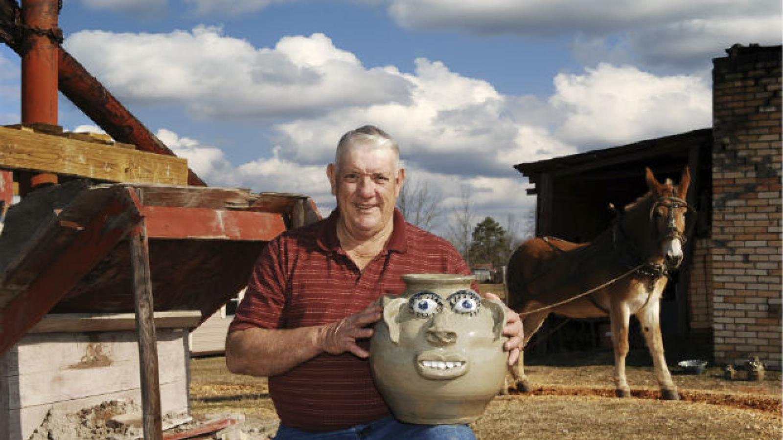 man kneeling outside with face jug