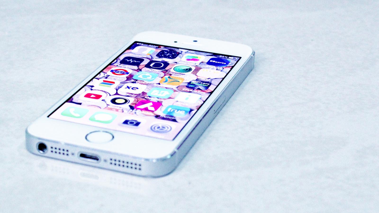 A white iPhone laying flat on a table. 