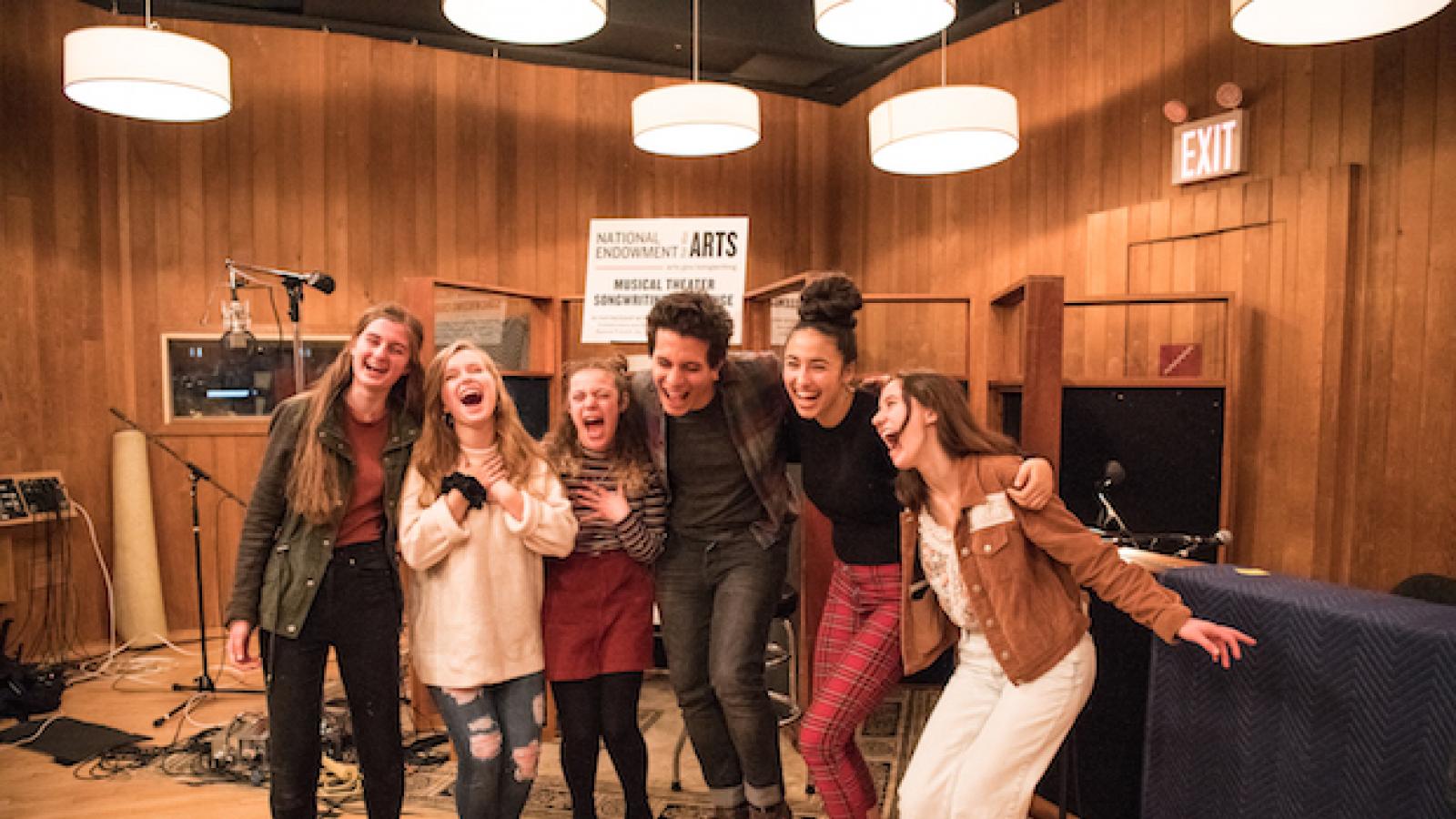 A group of young people smile for the camera.