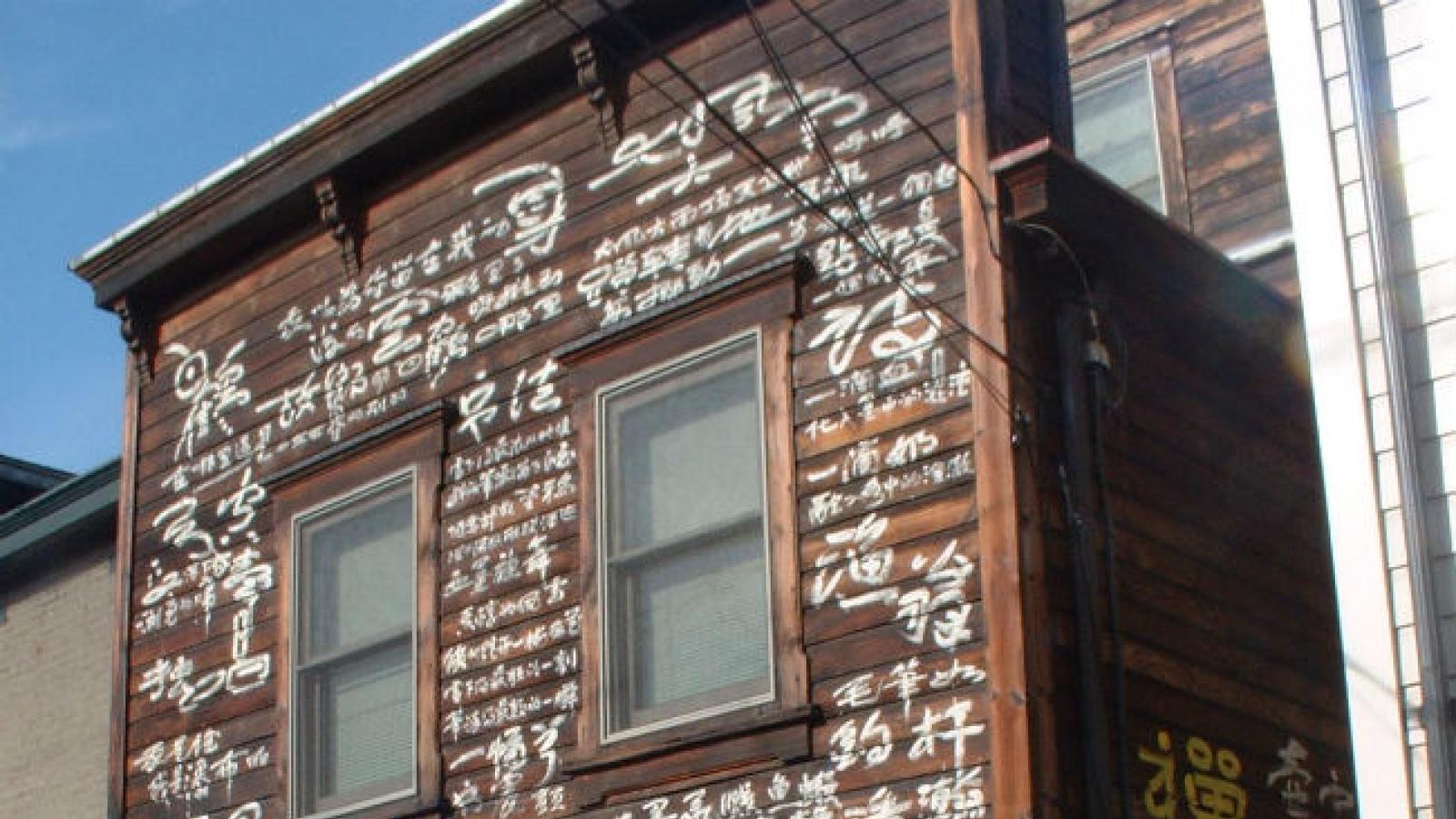 Chinese calligraphy covers a wood-slat house