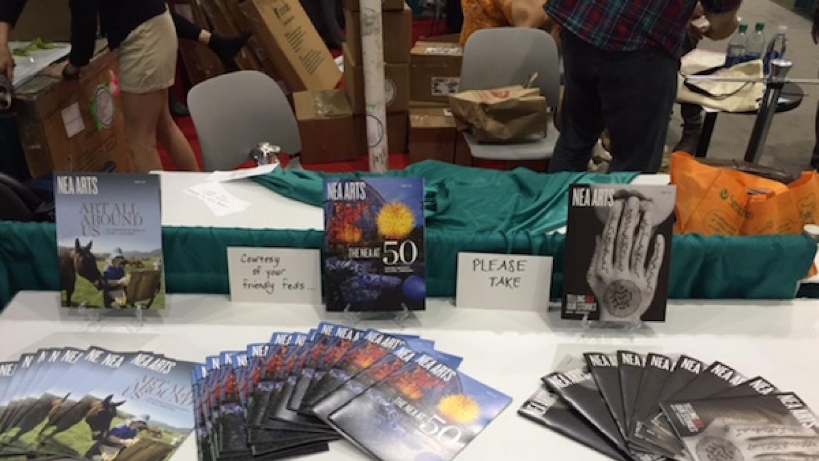 a conference table with various issues of NEA Arts magazine