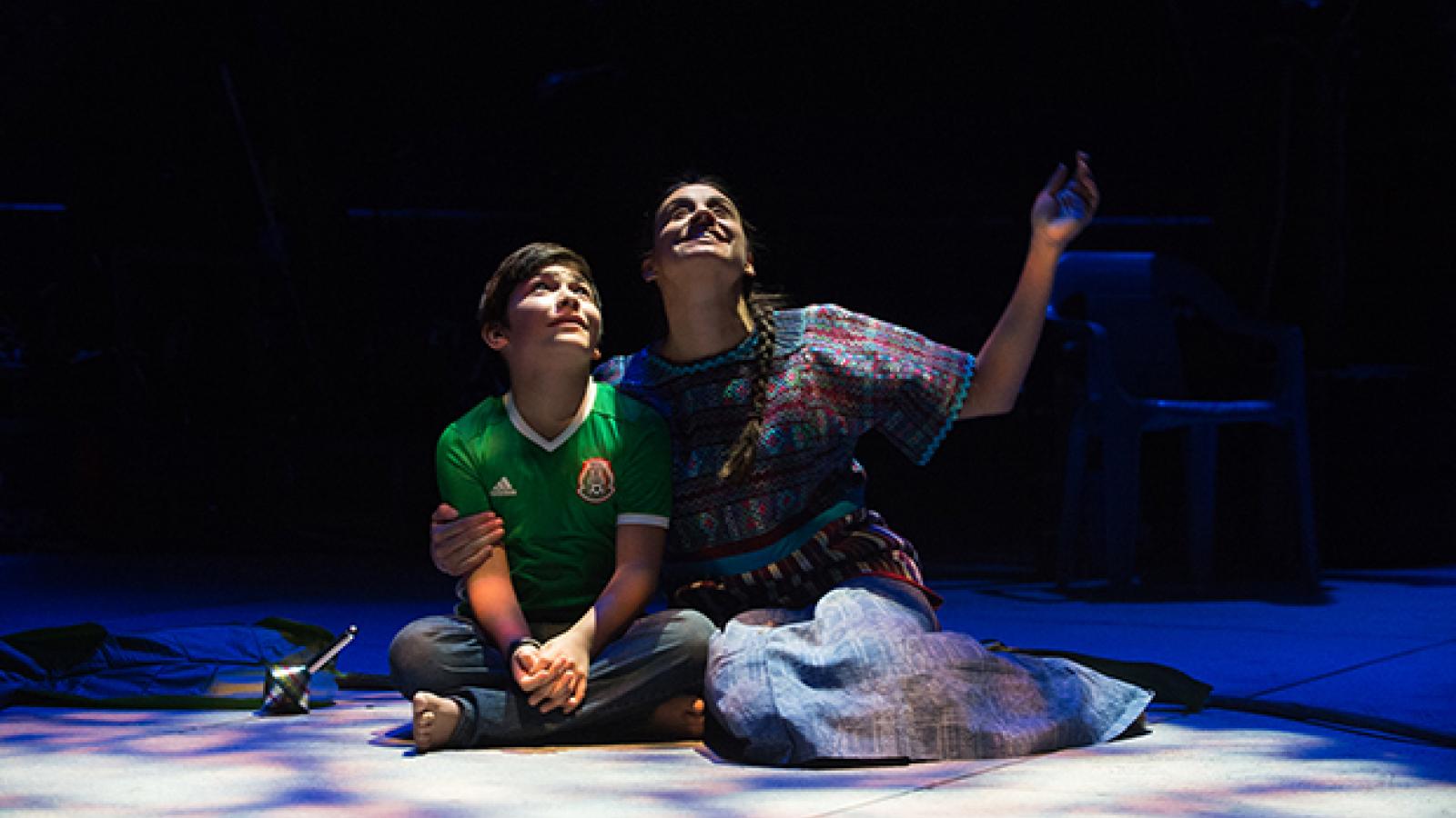 A scene from Mojada A Medea in Los Angeles Two actors sit on the stage and look at the sky