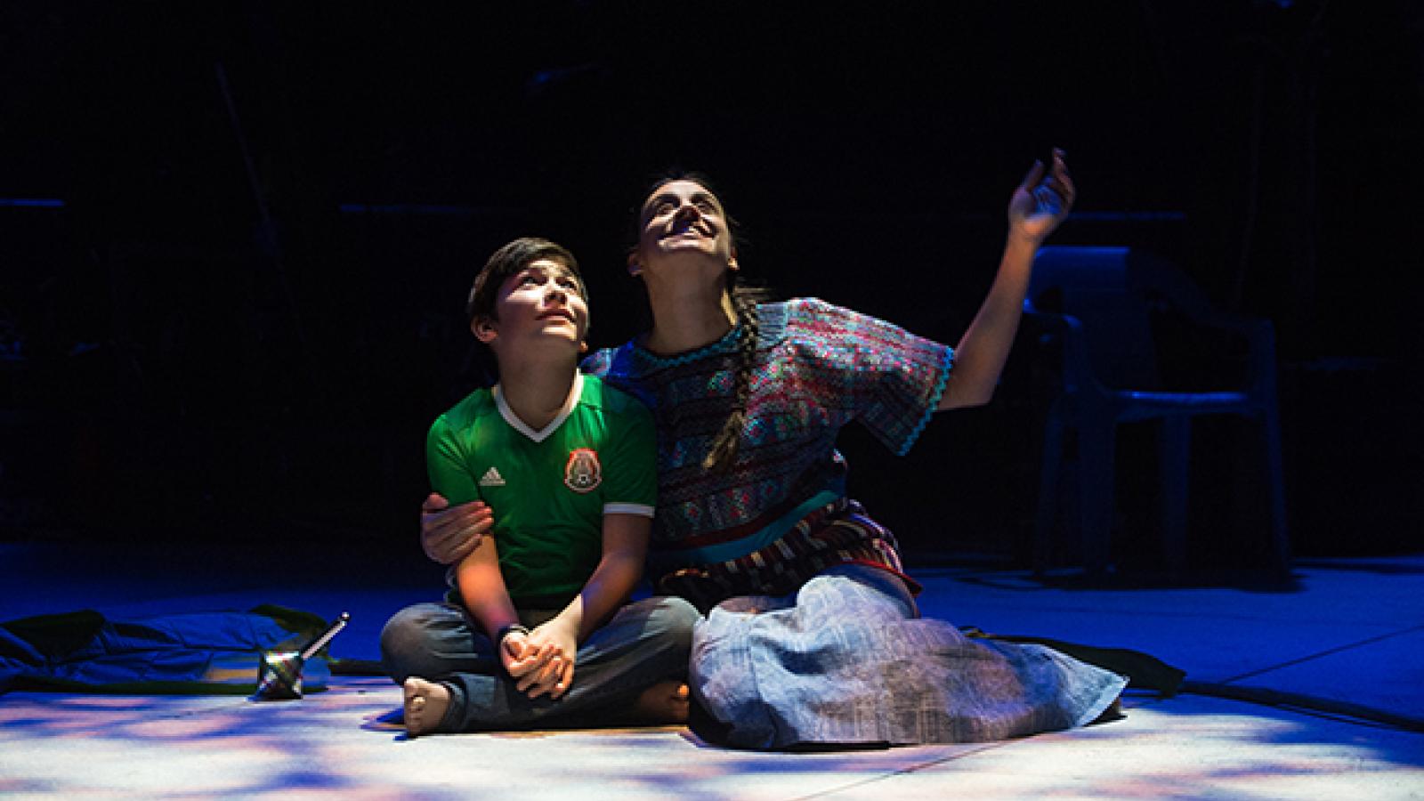 Two actors sit on the stage and look at the sky