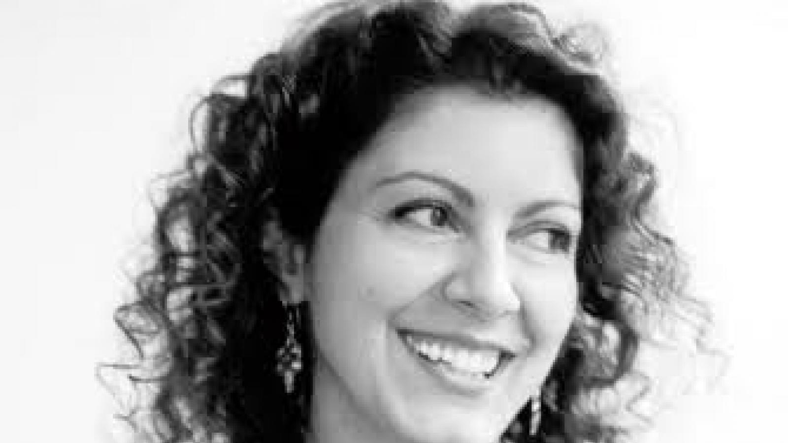 a young white woman with long dark curly hair
