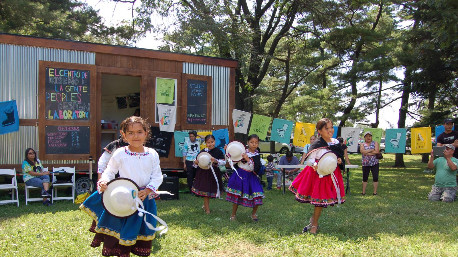 young girls dancing in the parks in front of a mobile art studio