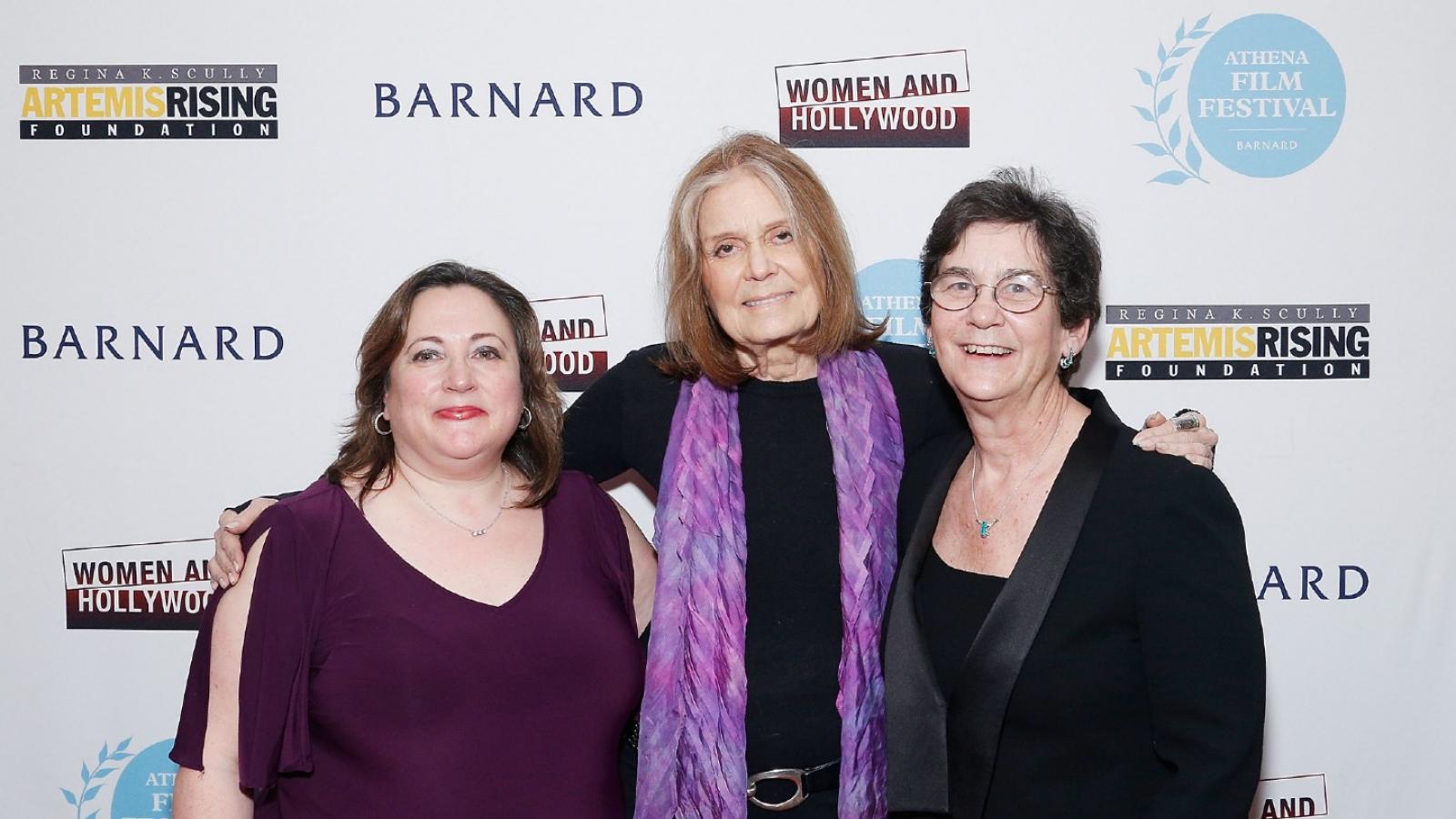 Melissa Silverstein, Gloria Steinem and Kathryn Kolbert Three women stand side by side with their arms around each other