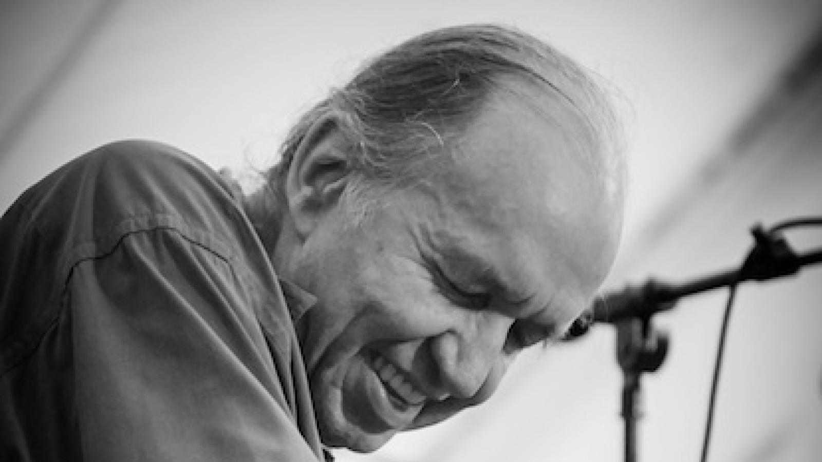 a man sits at a piano playing with his eyes closed