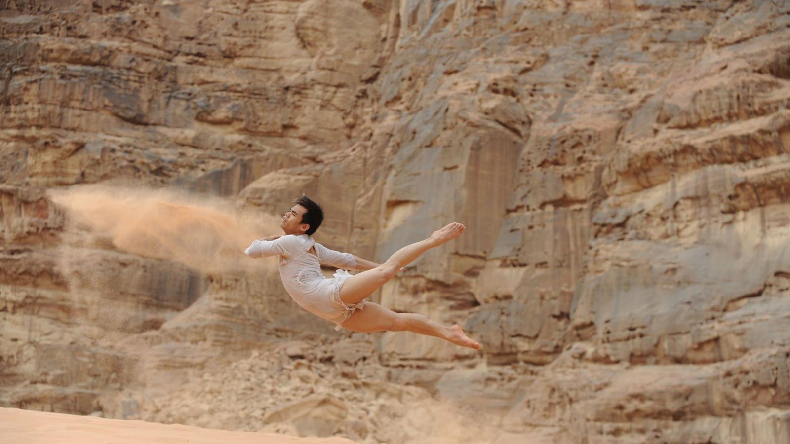 dancer leaping in the air in the desert