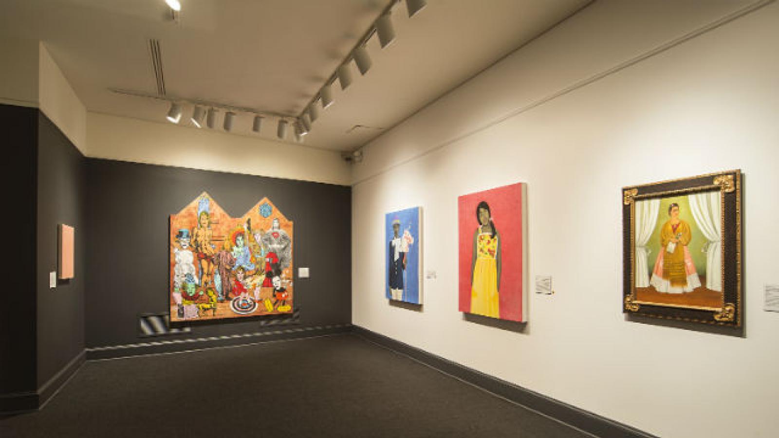 Room in a museum with paintings by women on the walls
