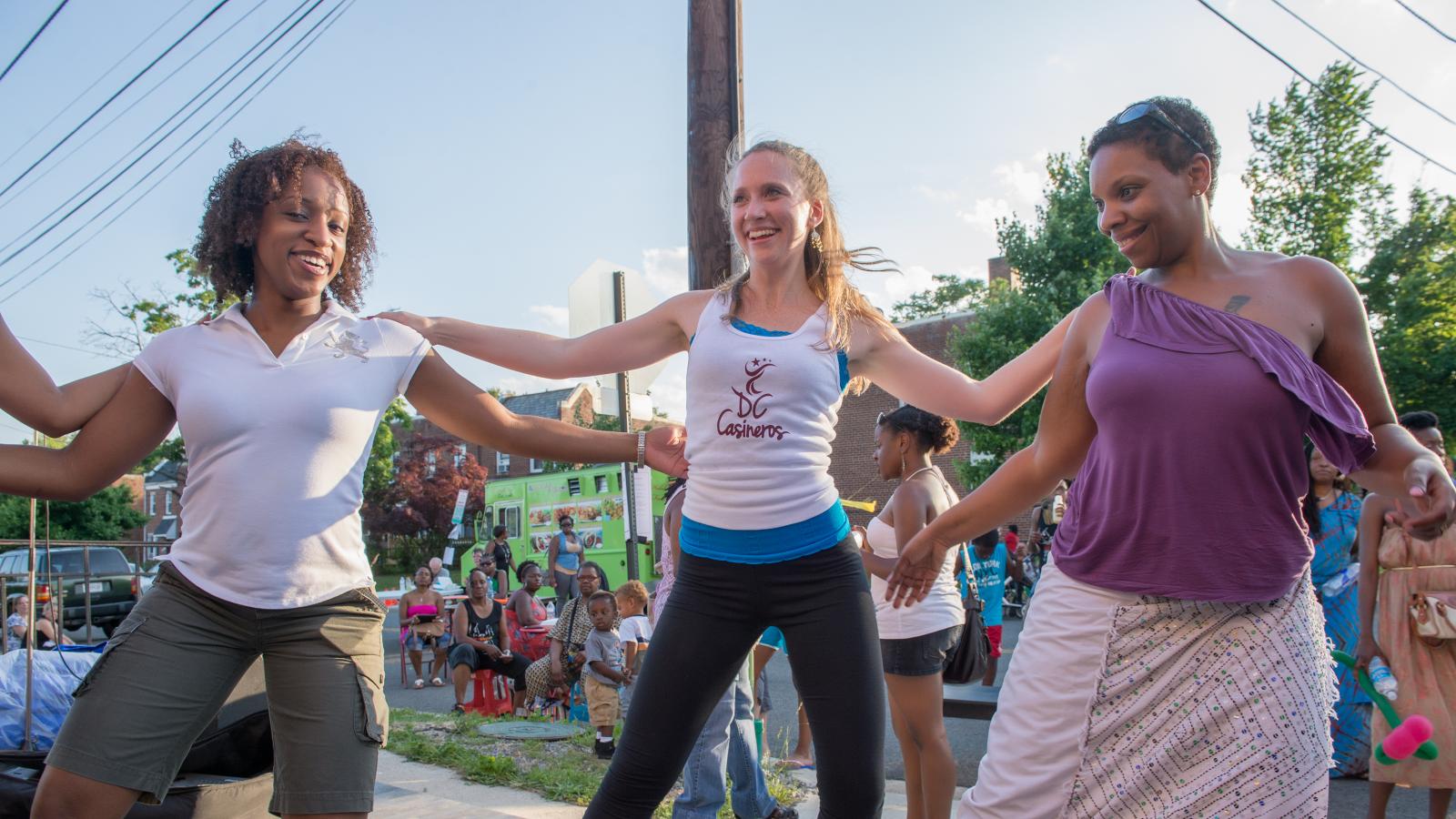 three women dancing outside