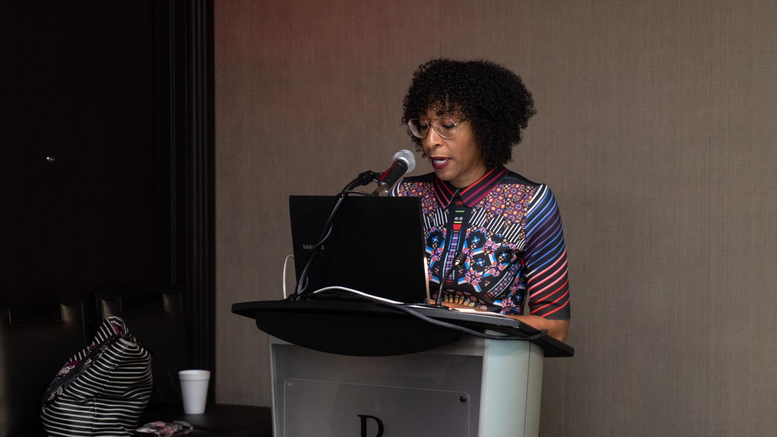 African-American woman speaking at podium.