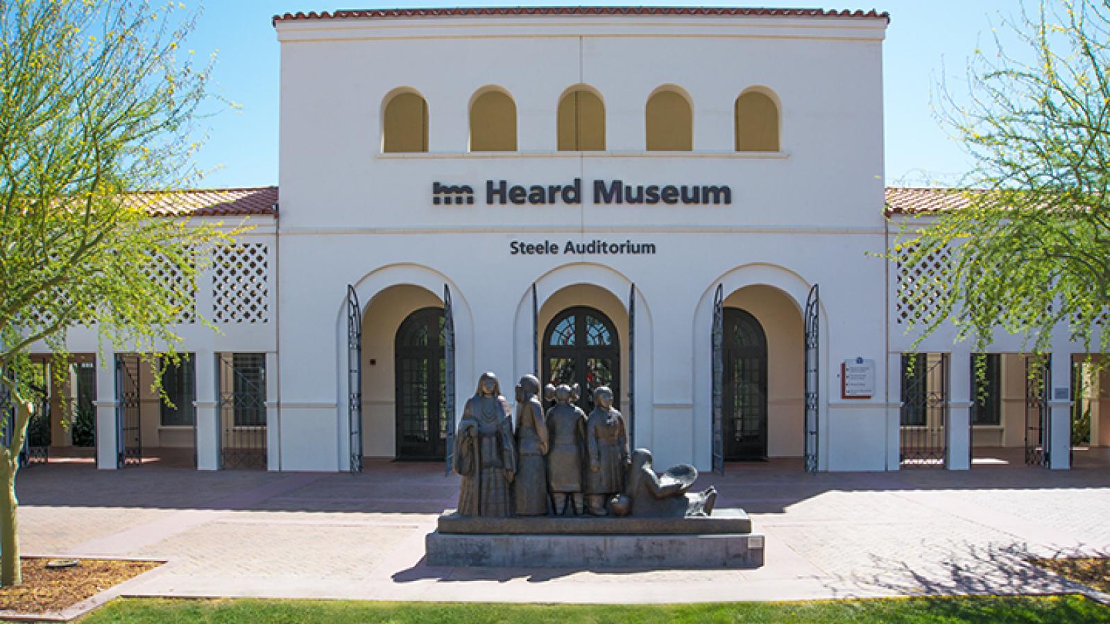 The entrance of Heard Museum, which has statues of American Indians posted in the front of the building. 