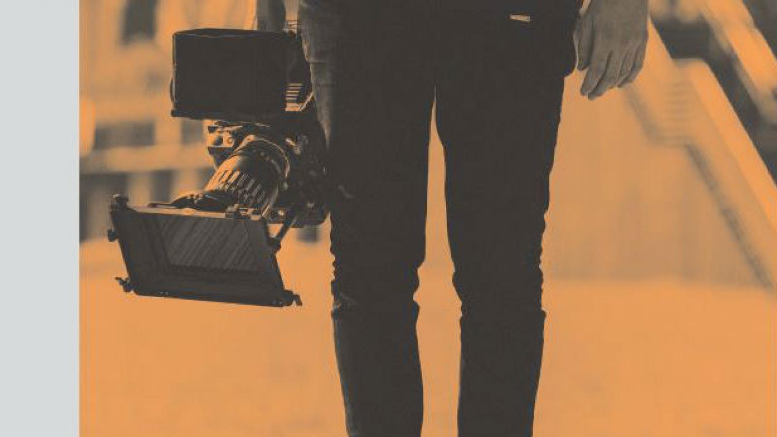 report cover with lower half of a camera man holding a camera