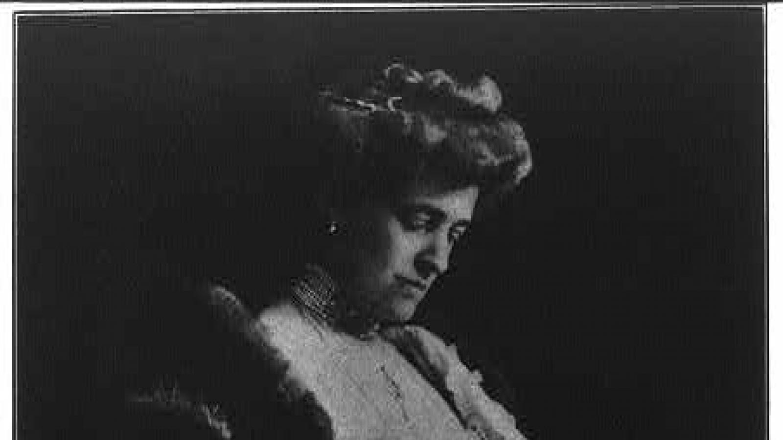 Author Edith Wharton standing and holding a book
