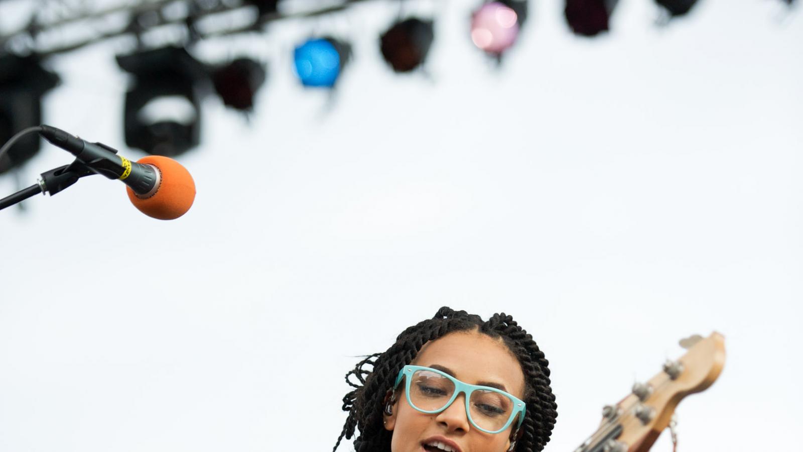 Esperanza Spalding playing the guitar on-stage.