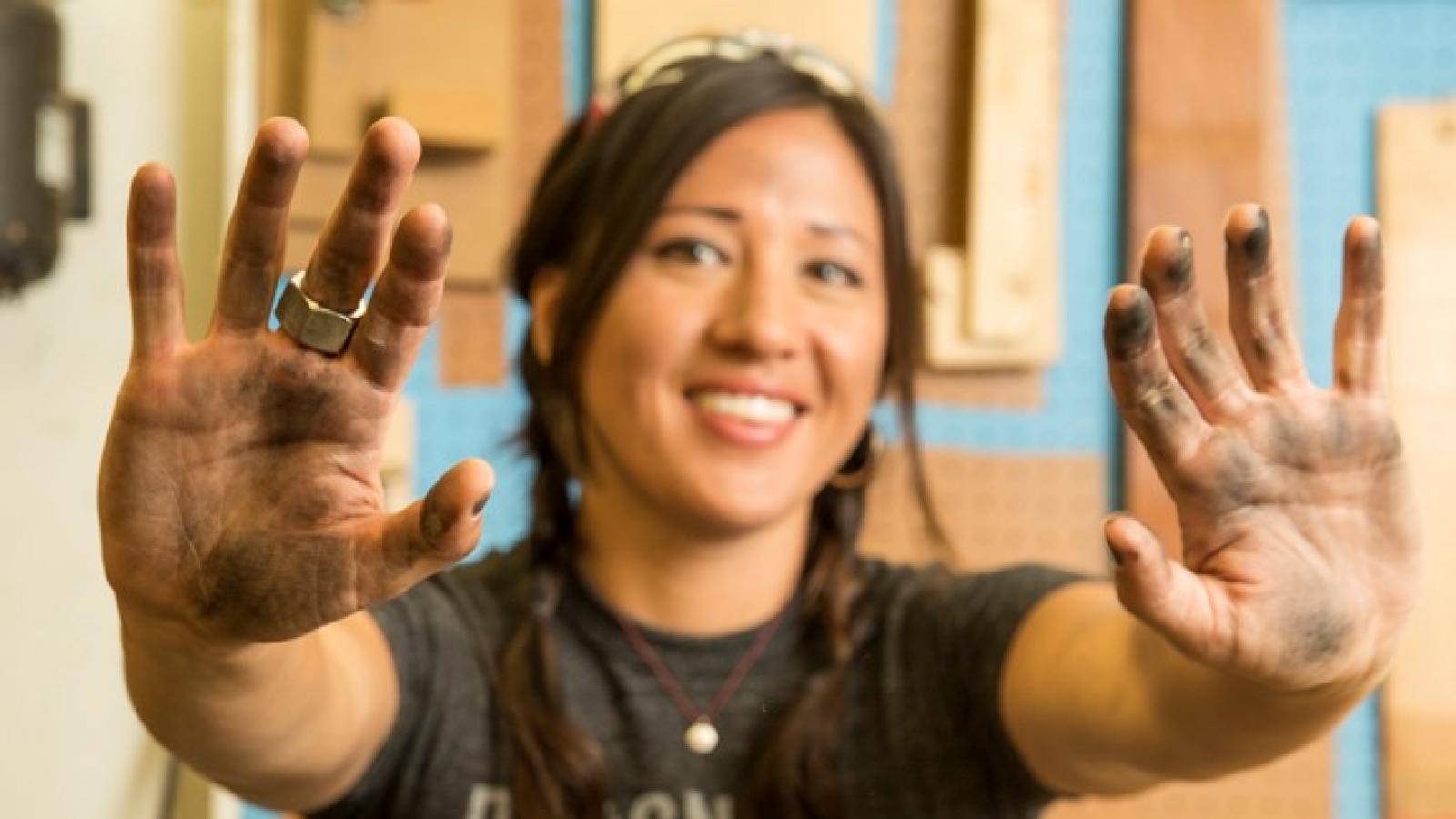 Woman holding out her hands full of ink. 