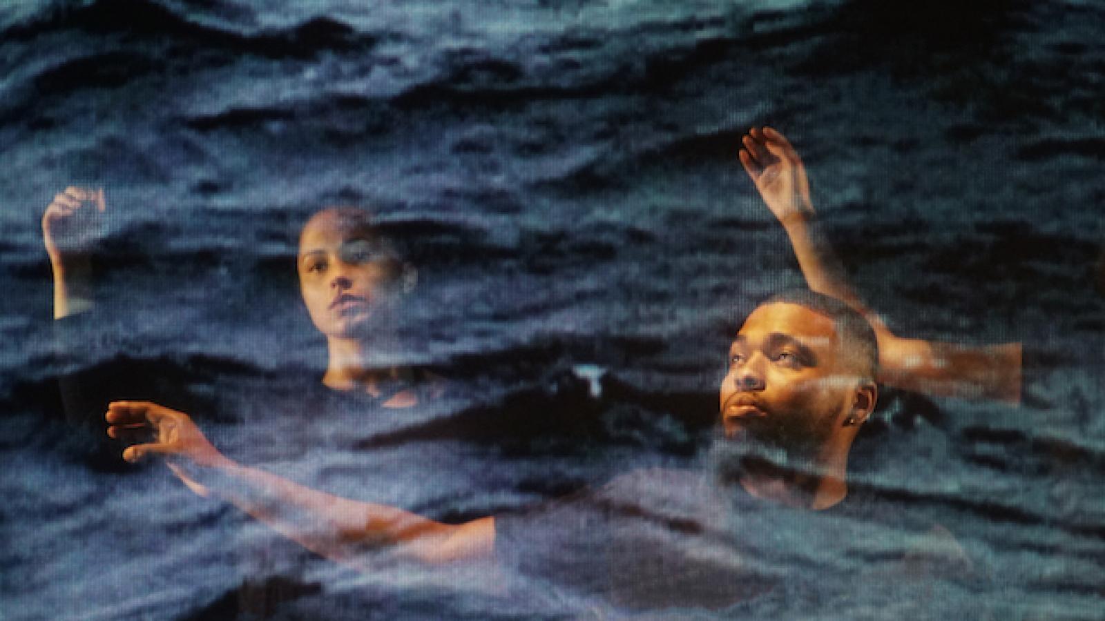 two people seen through a blue scrim