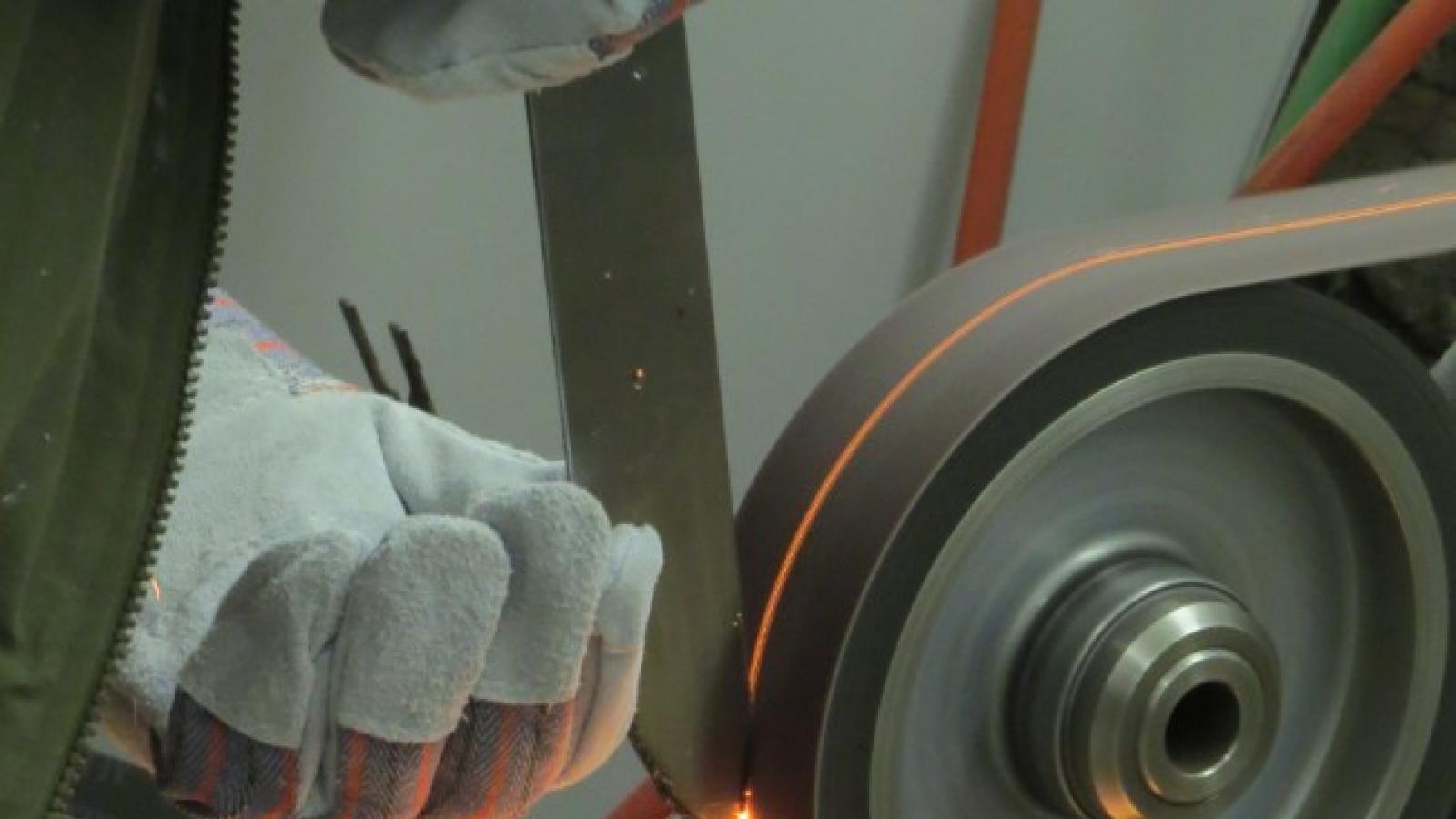 Appalachian Artisan Center Sparks fly from a grinder belt in a blacksmith studio