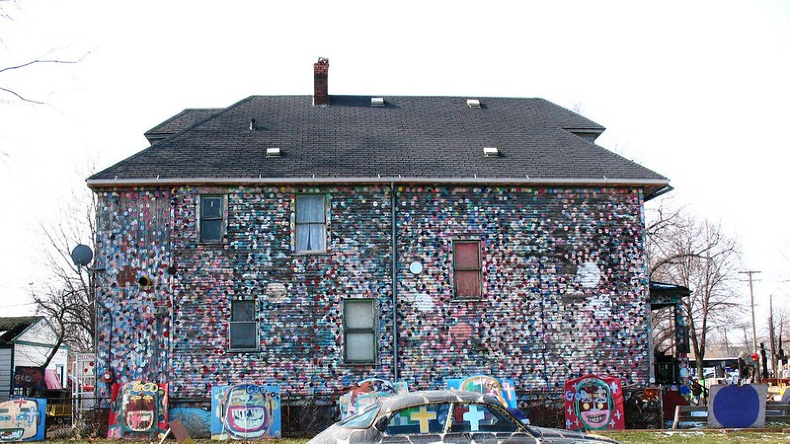 Heidelberg Street A house covered with colorful polka dots with colorful sculptures made from trash in the front yard