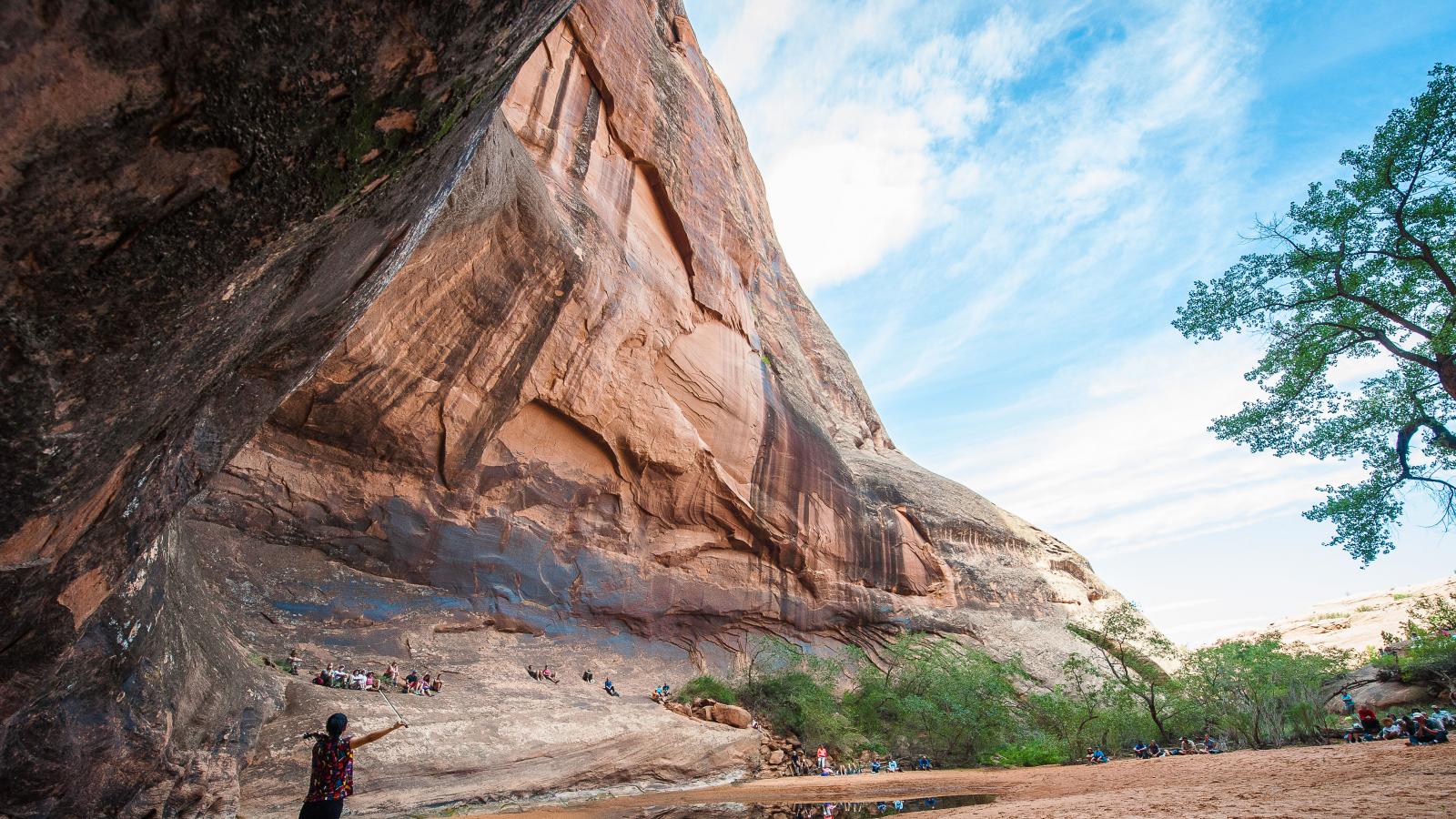 A woman standing on the edge of a red rock canyon overlooking the festival.