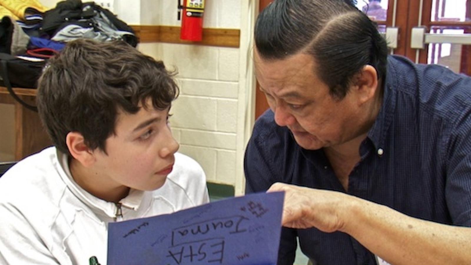 a young boy and an older man work on an art project together