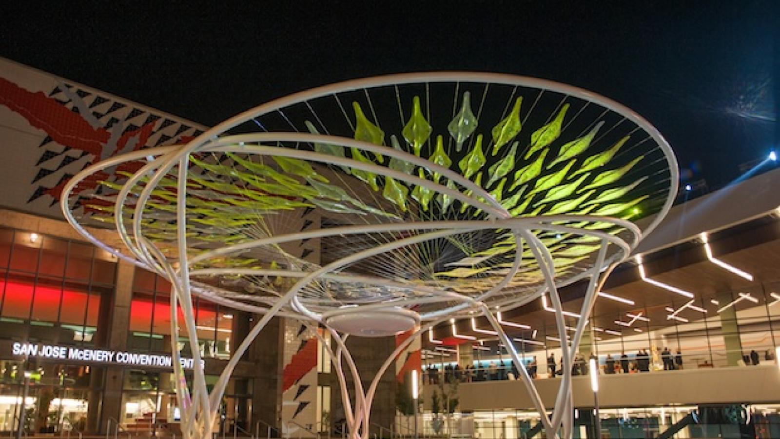 a two-story tree-like sculpture with a series of white trunks holding up a canopy of attached leaf like translucent shapes