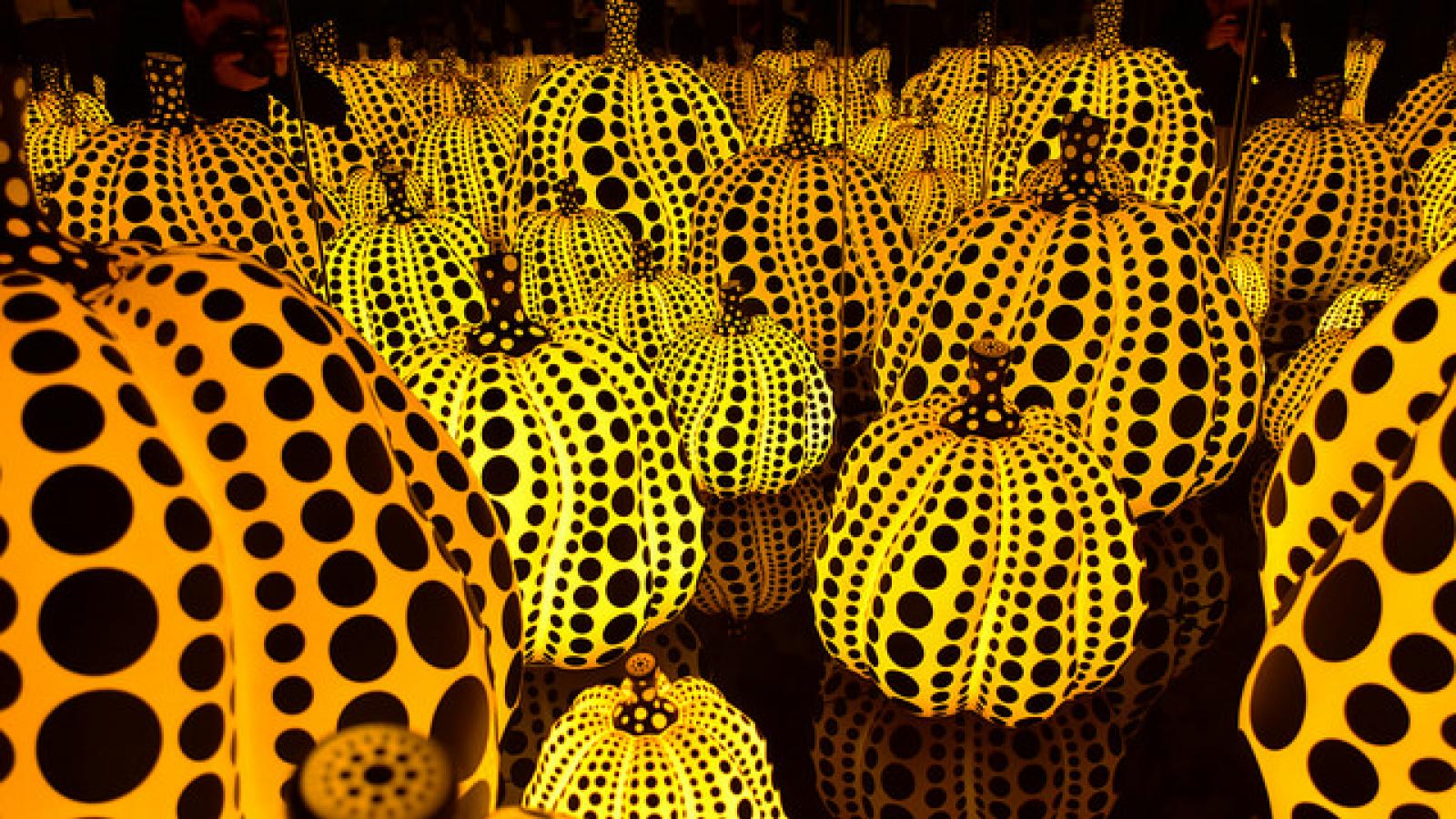 Rows of yellow glowing glass pumpkins covered with black polka dots