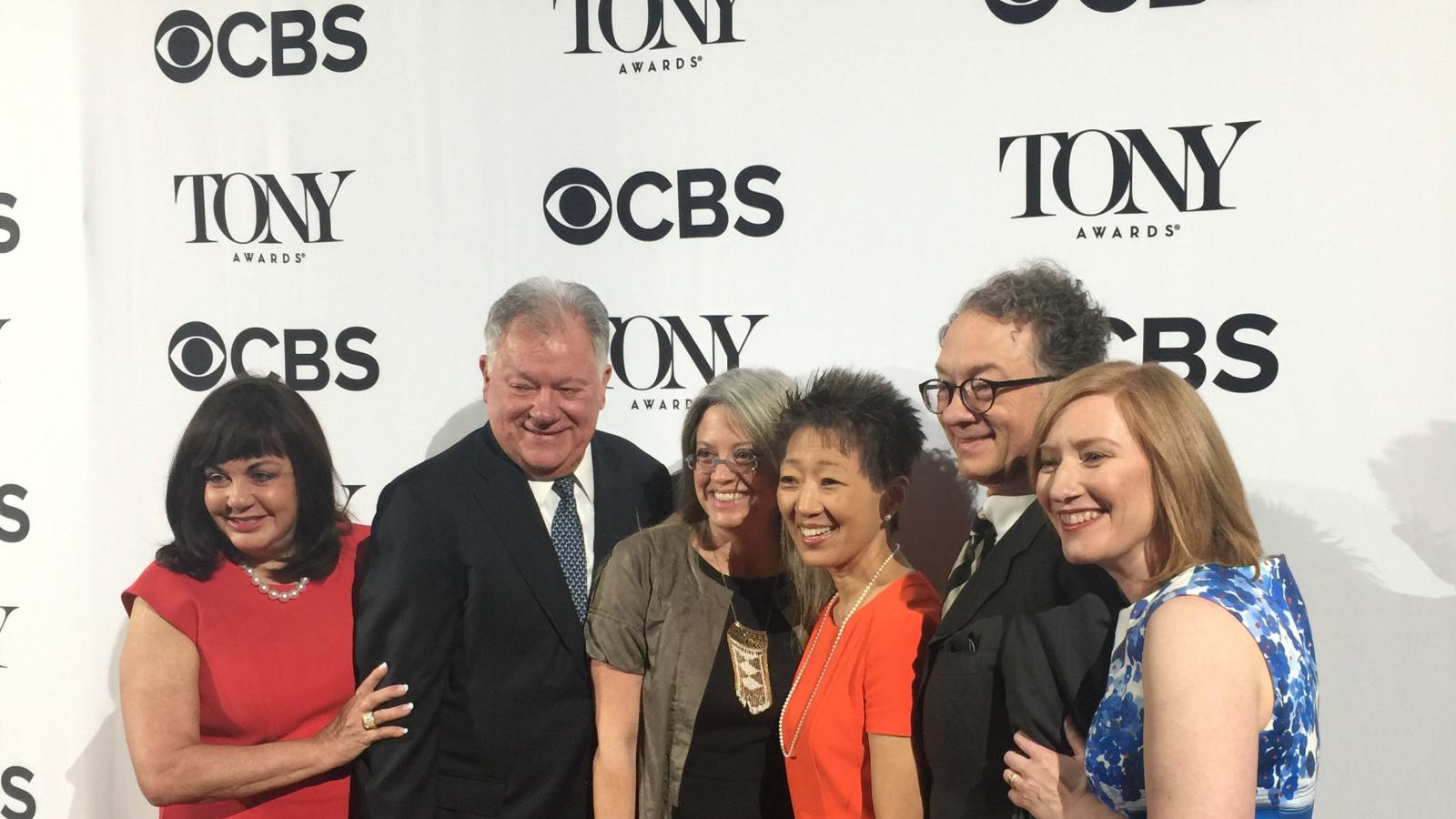 6 people in group in front of banner with Tony Awards and CBS logos