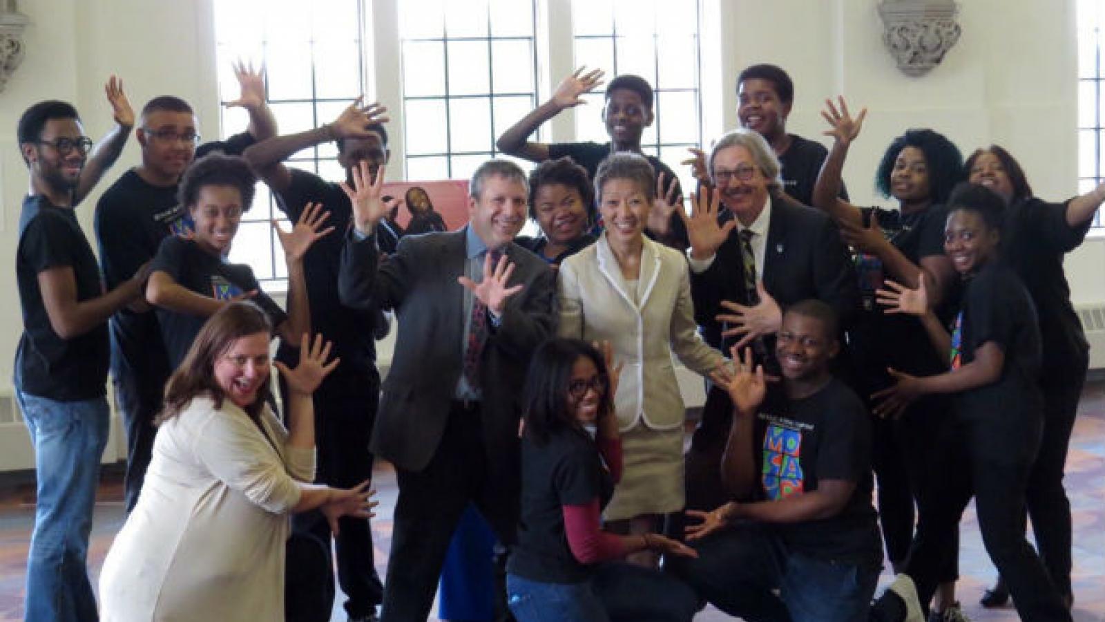Theater students surrounding NEA chairman Jane Chu