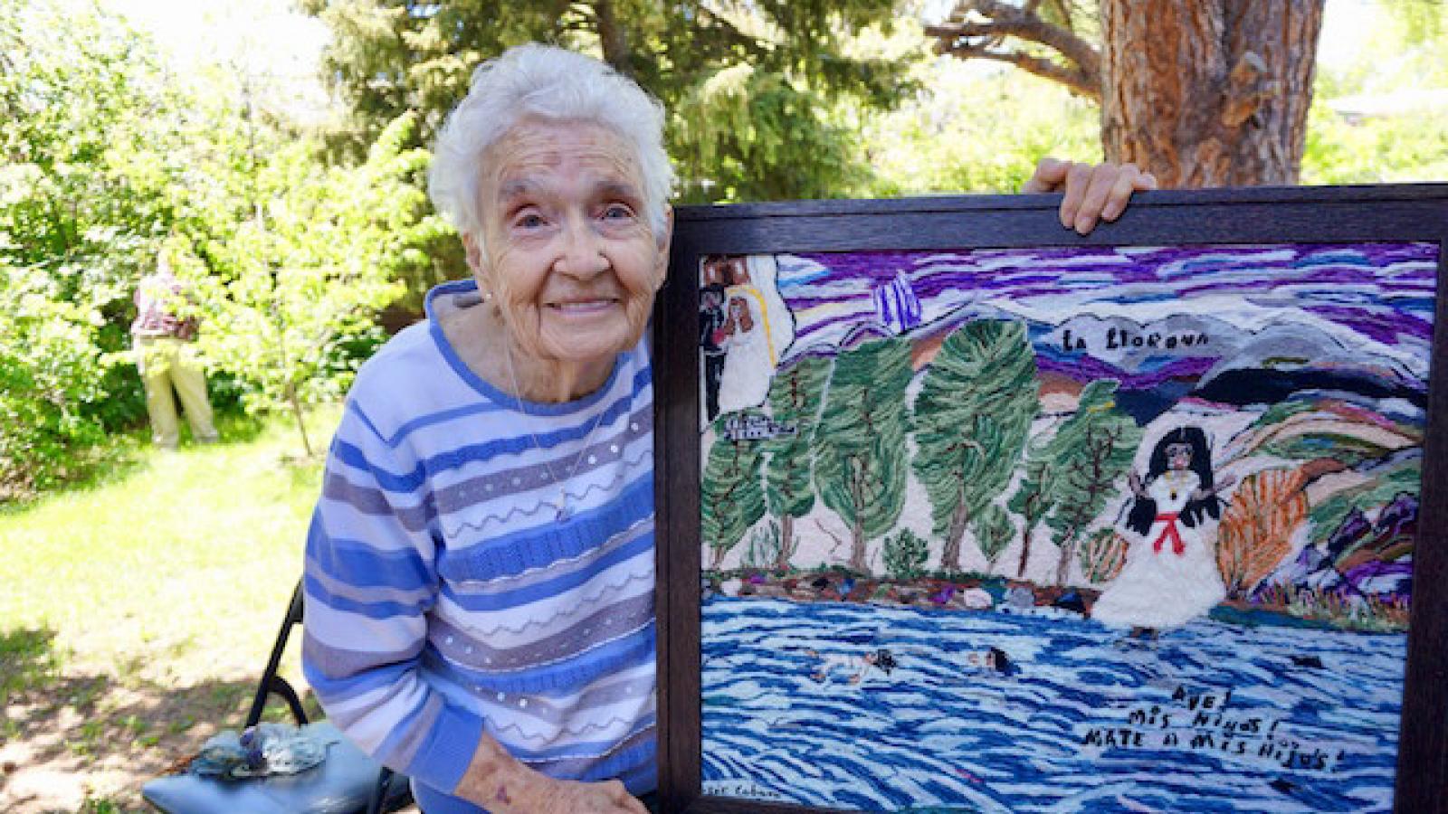 Josephine Lobato holding a piece of her embroidery