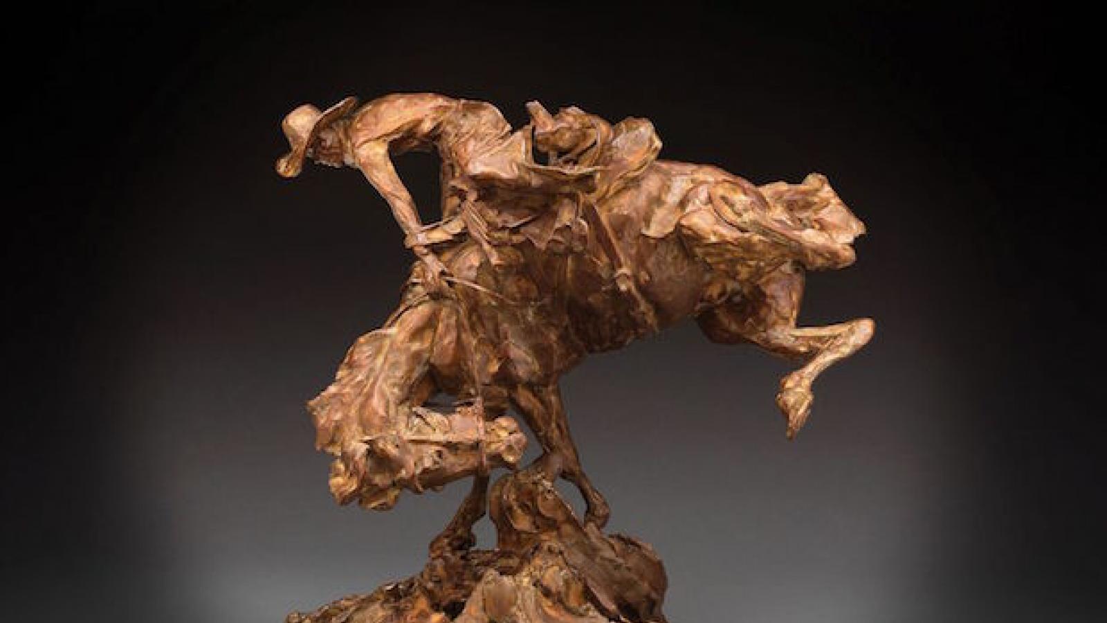 photo of a bronze sculpture of a cowboy riding a bucking horse