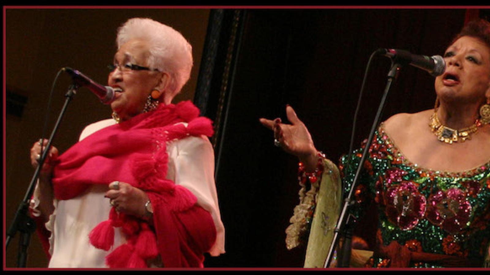 two older women in fancy gowns singing