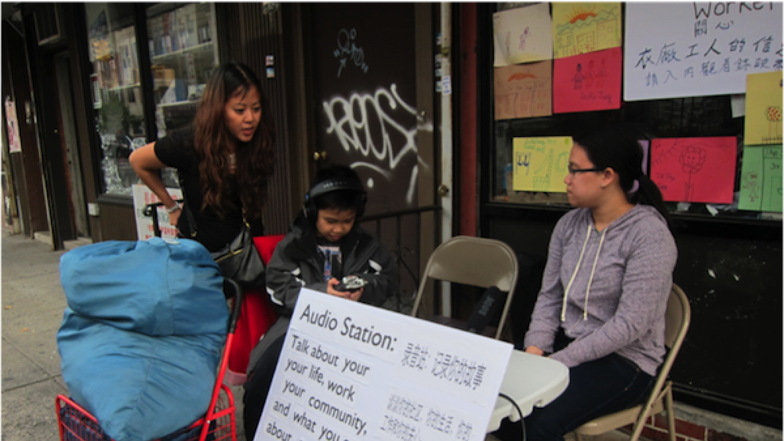 a woman sits outside a laundromat with a sign