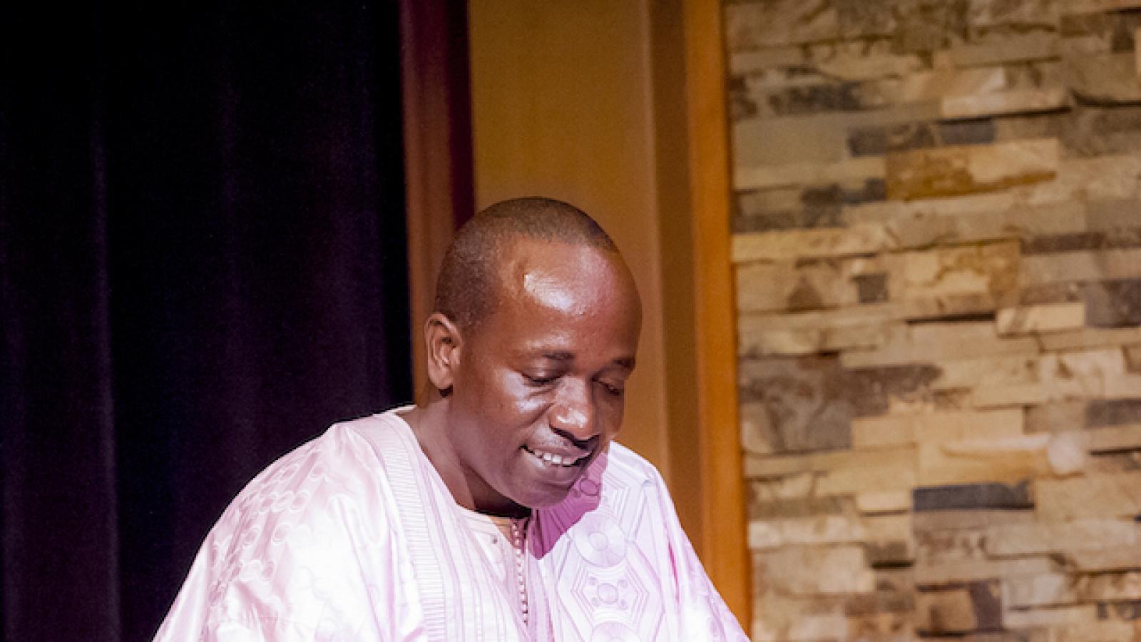 a dark-skinned man playing a balafon