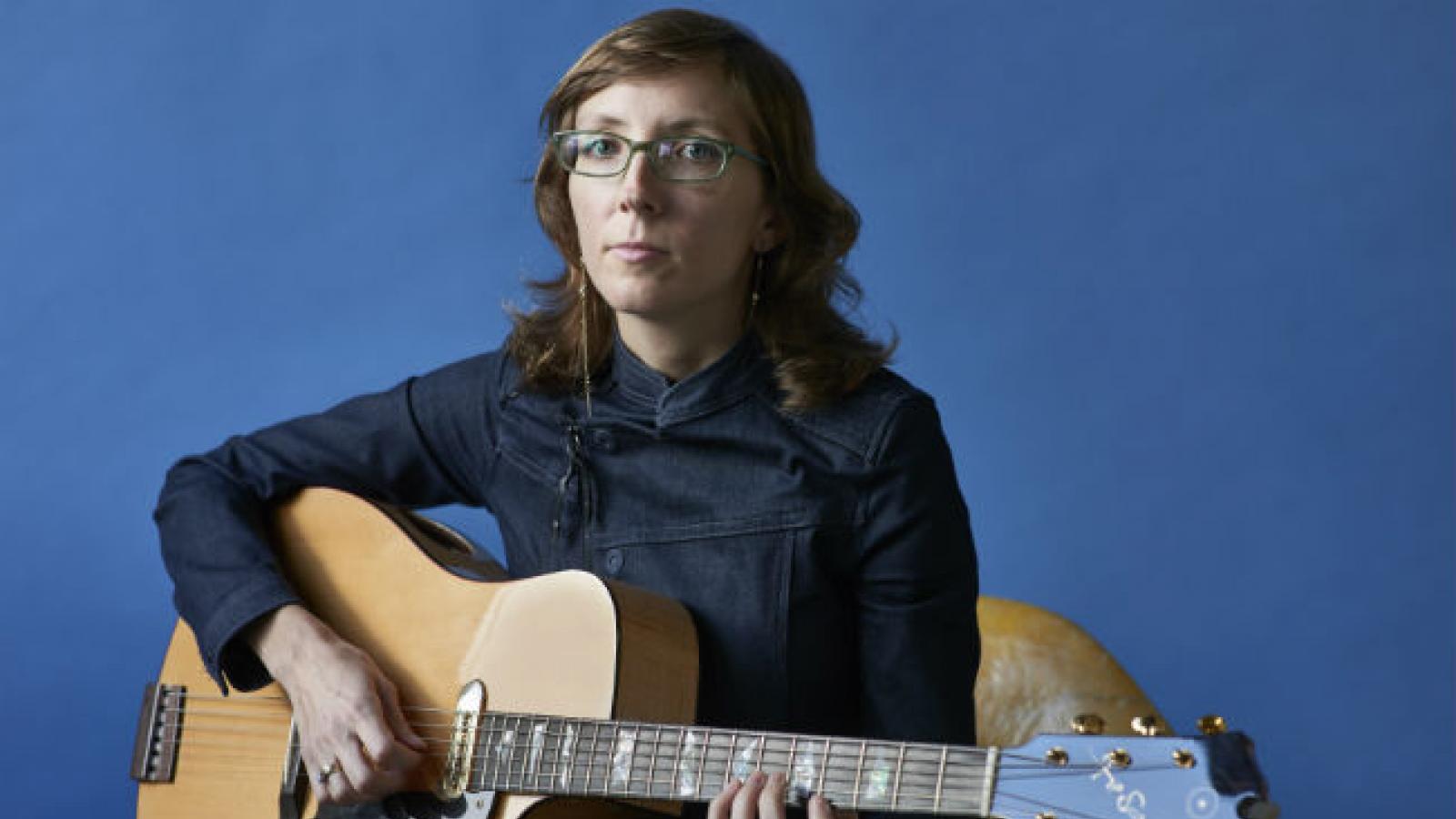 Woman in glasses holding a guitar