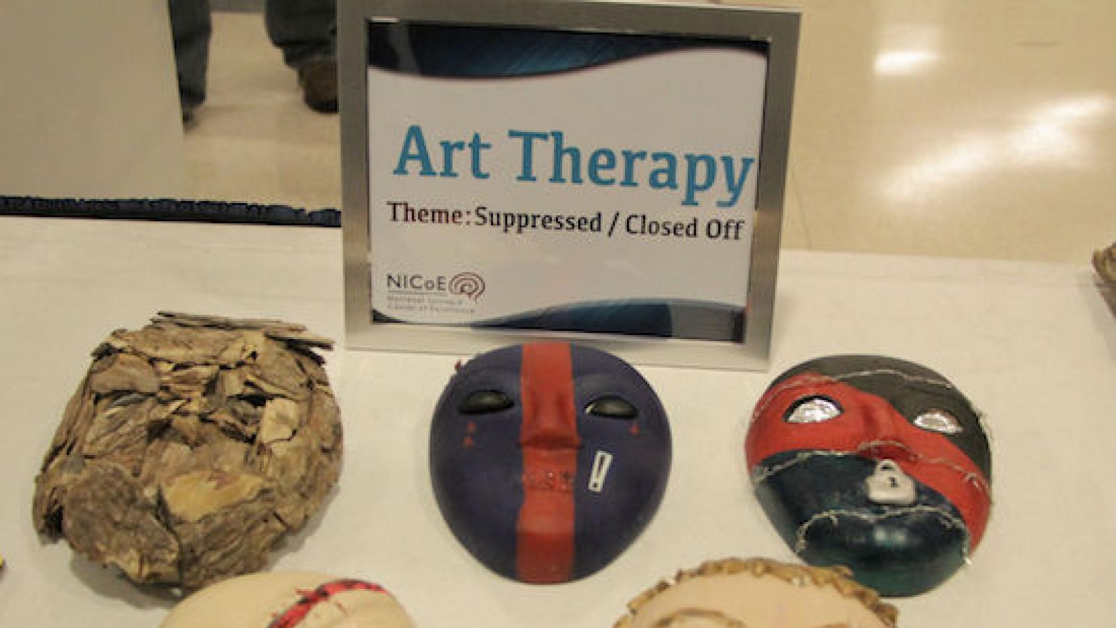 papier mache masks made in art therapy displayed on a table at a Walter Reed event