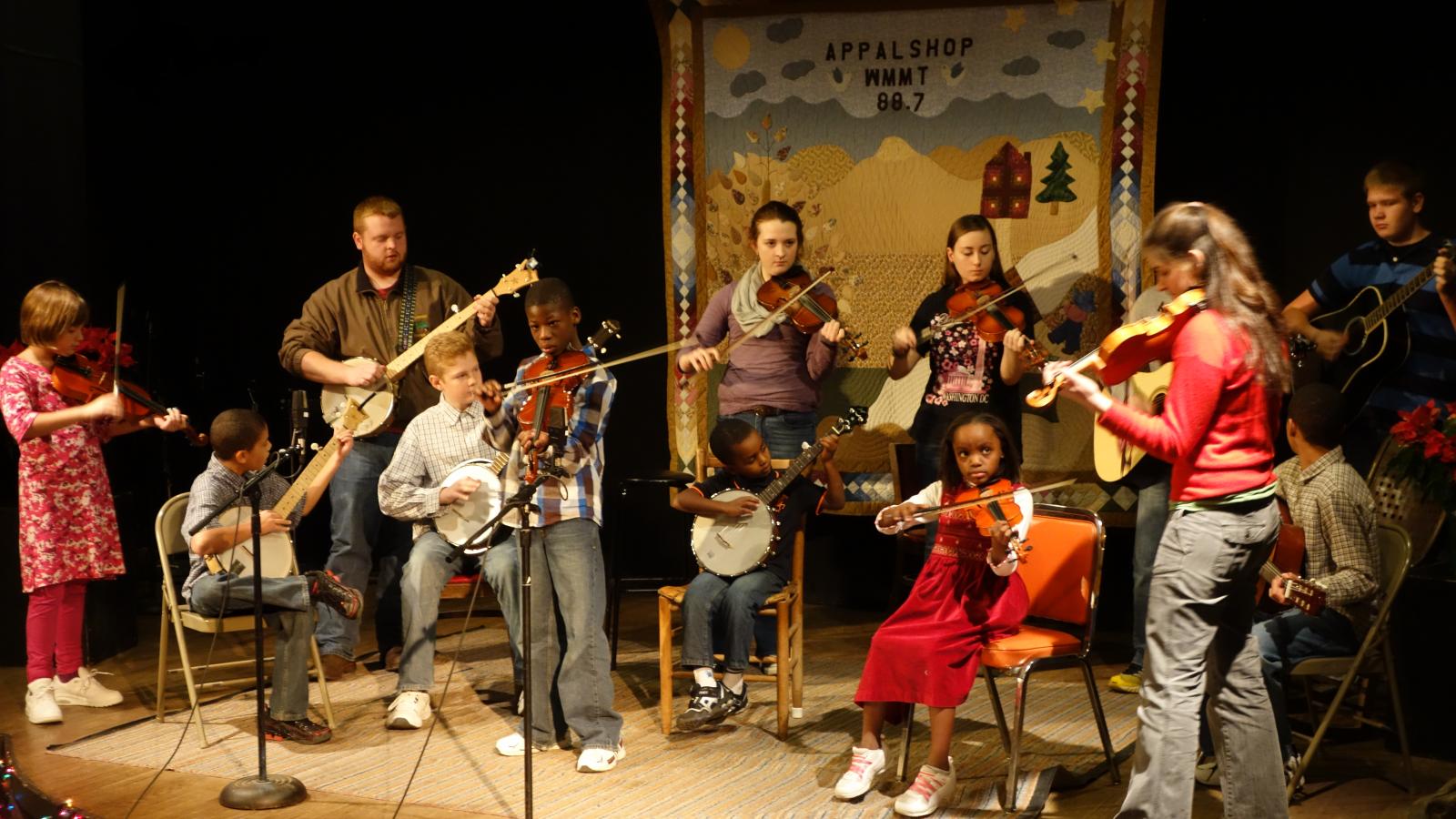 Small stage with young people playing musical instruments