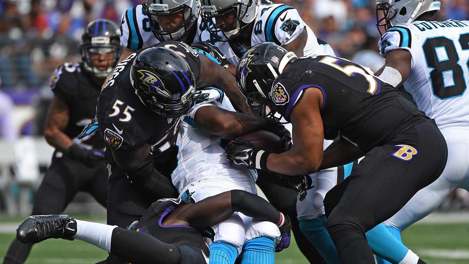 Football players tackling one another.