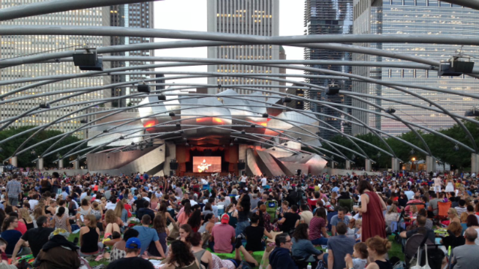 The Pritzker Pavilion The silver Pritzker Pavilion in with audience in front sitting on grass