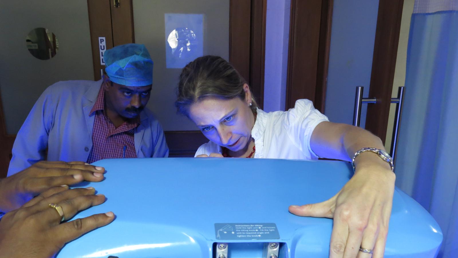 Woman and man looking at phototherapy machinery.