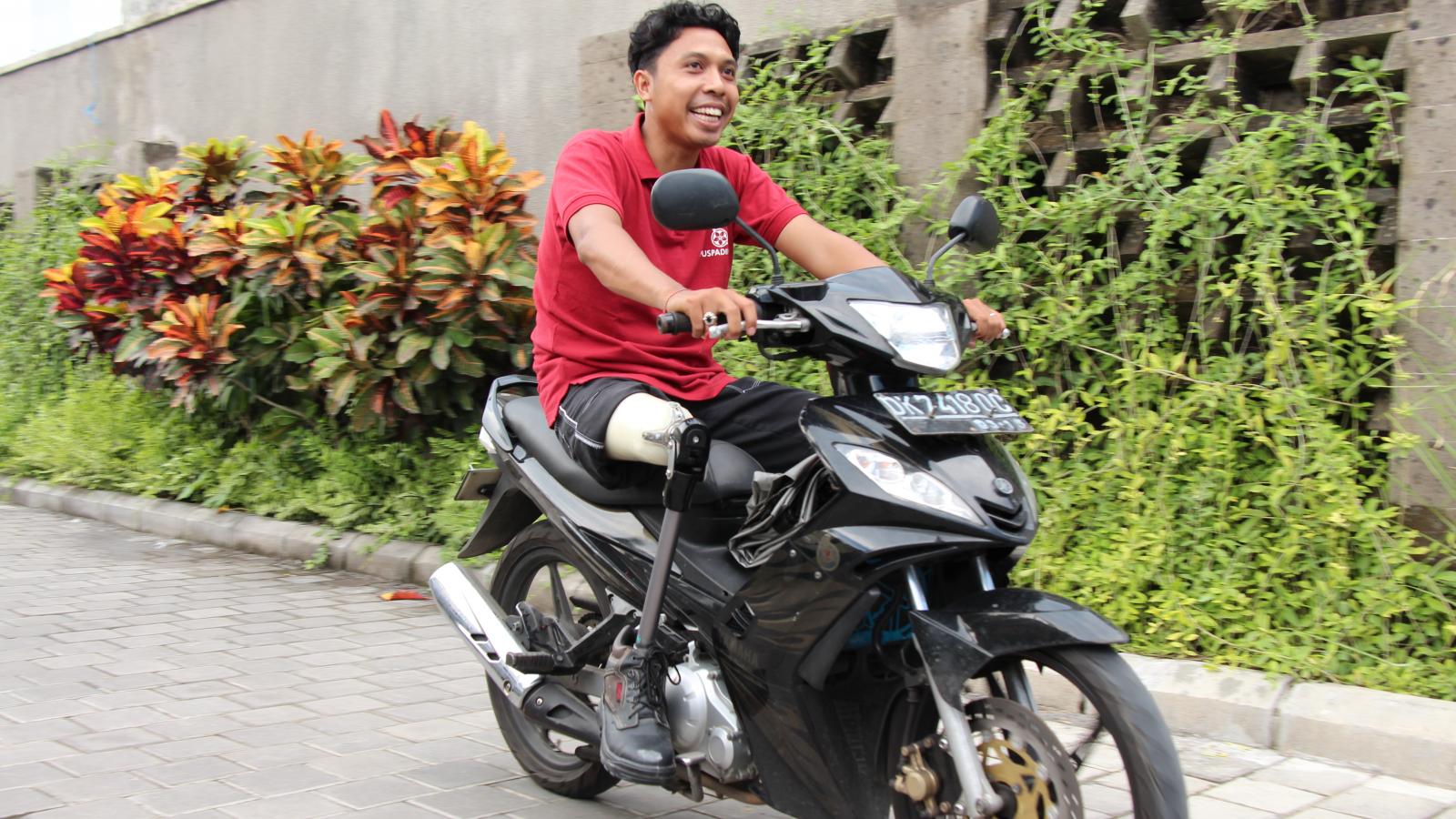 Man with prosthetic leg riding a motorbike.