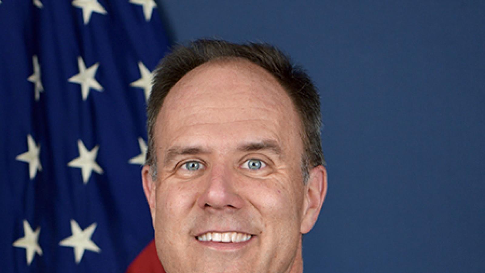 Portrait of Chris Gerdes in front of U.S. flag.