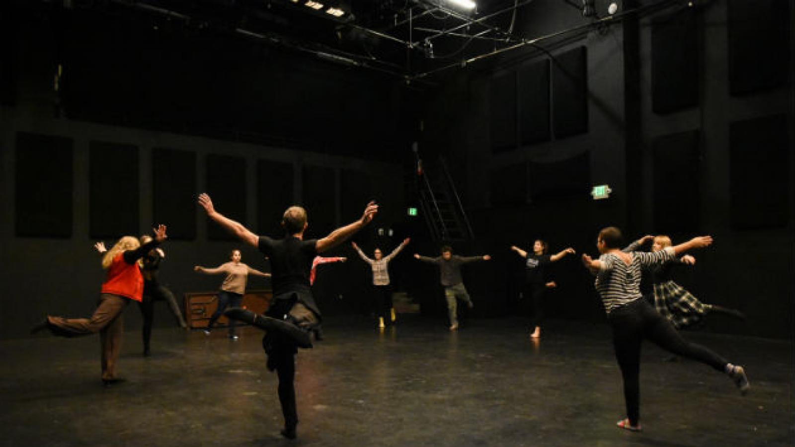 A dance workshop at Avanti High School A man and high school students stand in a circle doing arabesques