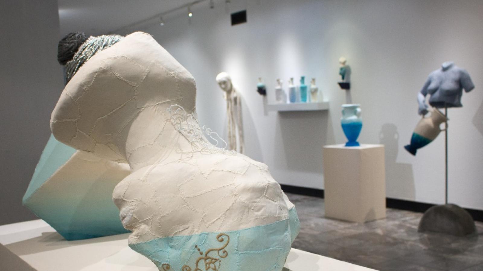 High Tide by Tasha Lewis A sculpture of a blue, white & gold head turned upside down