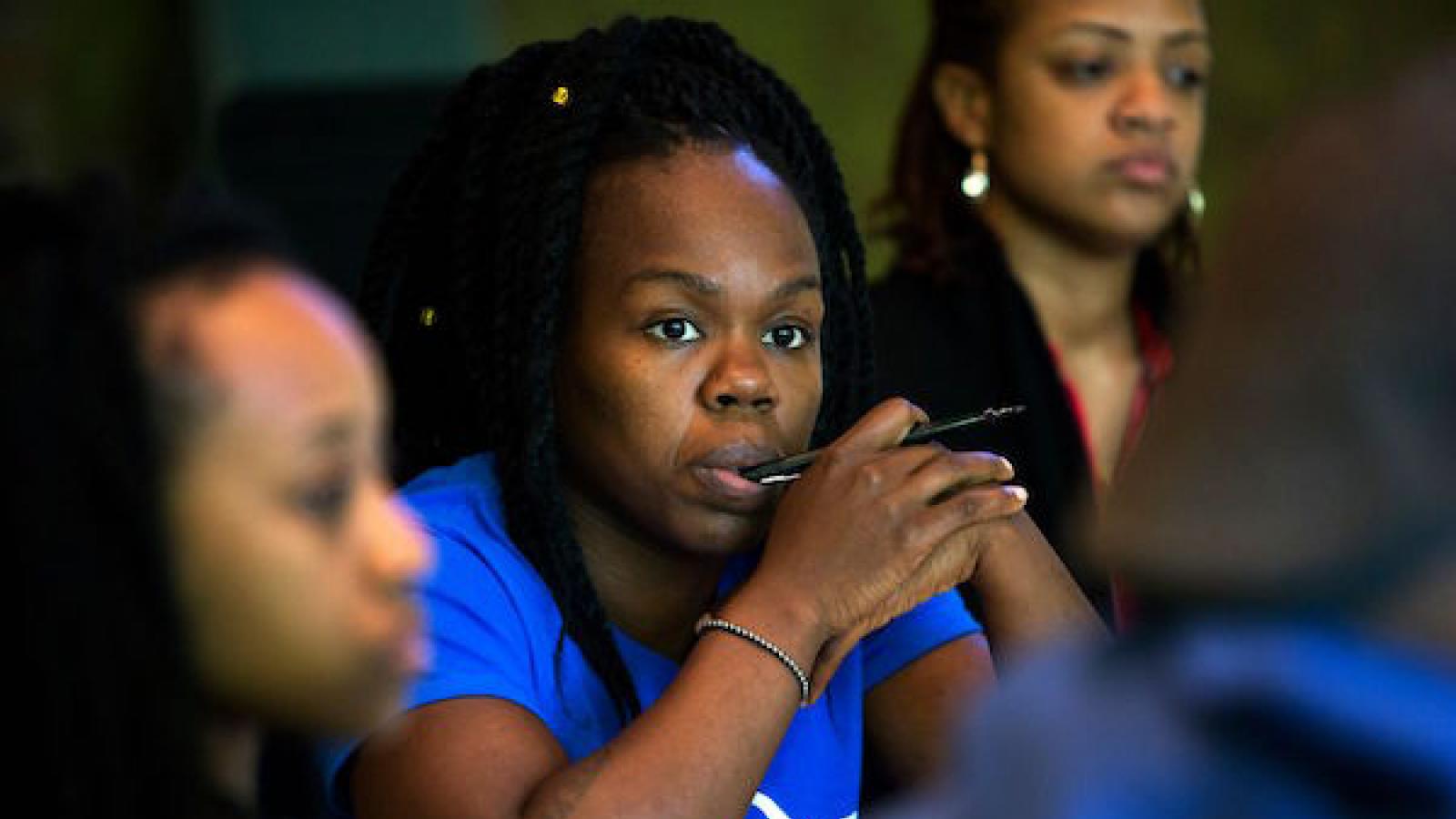three African-American woman theater artists watching a performance that is out of the frame
