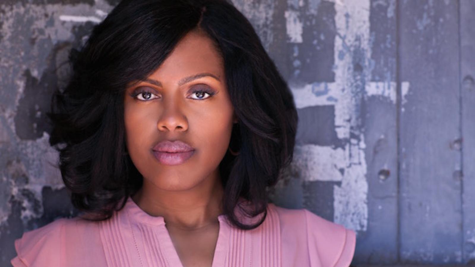 a young black woman with straightened hair and pink lipstick