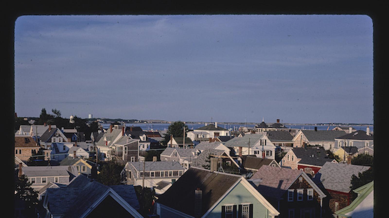 photo of variously colored rooftops in an oceanside town