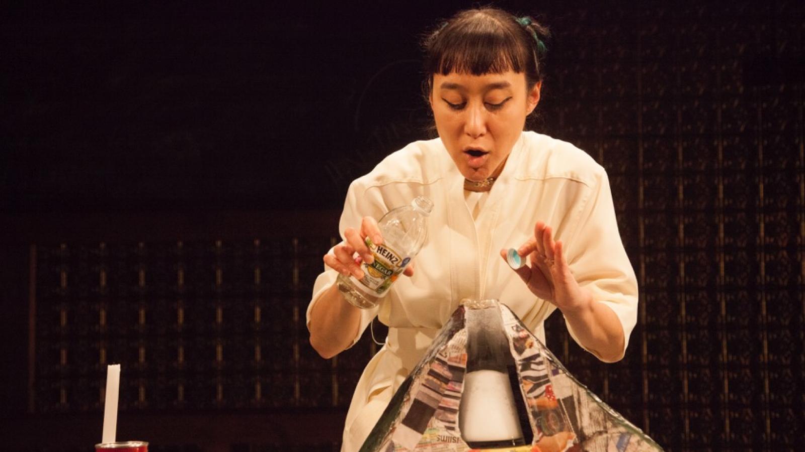 Production still of Hai-Ting Chinn's "Science Fair" Woman preparing to conduct a volcano baking soda science experiment