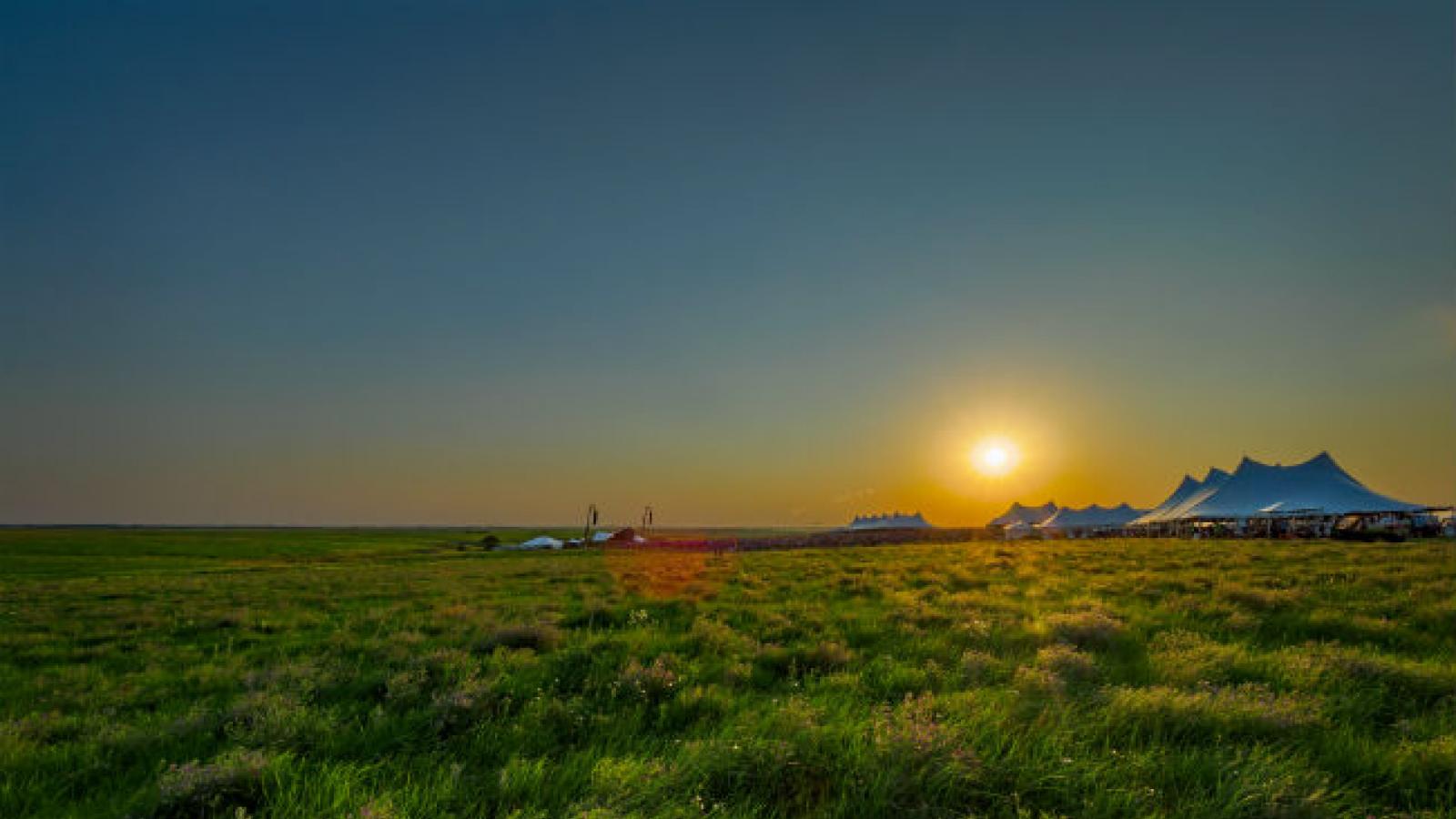 Symphonic performance in the Kansas prairie White tents at sunsets in middle of Kansas grassland prairie